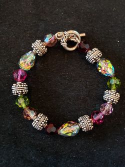 Beautiful iridescent, purple, red, silver bead bracelet with toggle clasp. Heavy. 7.5 in long and 3/8 in wide.