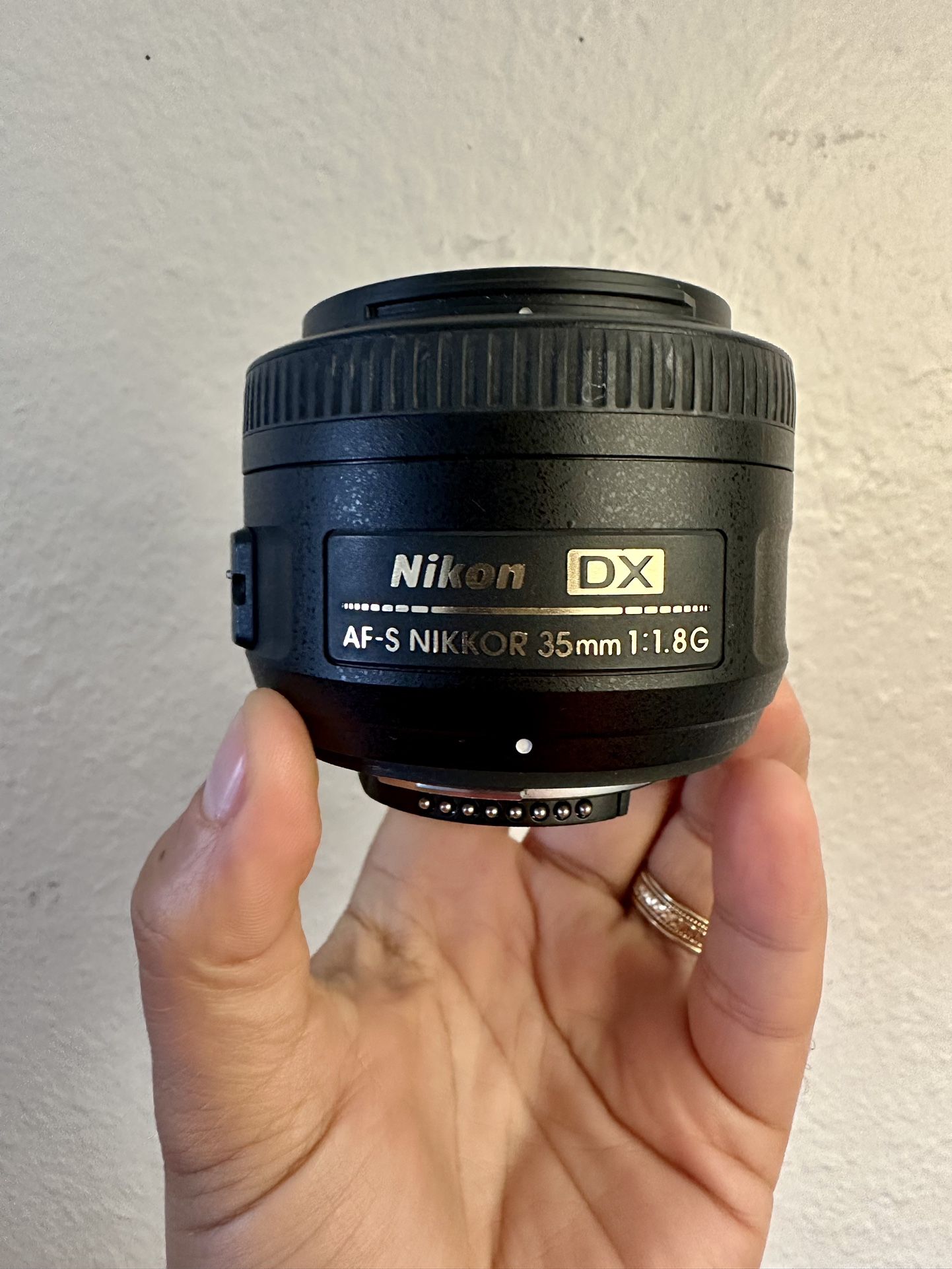 Nikon AF-S DX NIKKOR 35mm f/1.8G Lens with caps for front and rear, hood, and bag. 