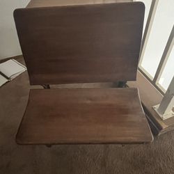 This is an antique wooden school desk with a cast iron base. 