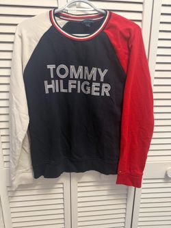 Tommy Hilfiger colorblock crewneck sweatshirt featuring a navy body, white left sleeve, and red right sleeve with outlined lettering across the chest.