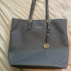 Dark silver, Michael Kors purse will fit a laptop