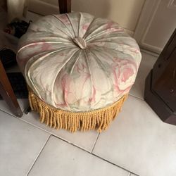 vintage-style round tufted ottoman (or tuffet) featuring a floral print and bullion fringe trim
