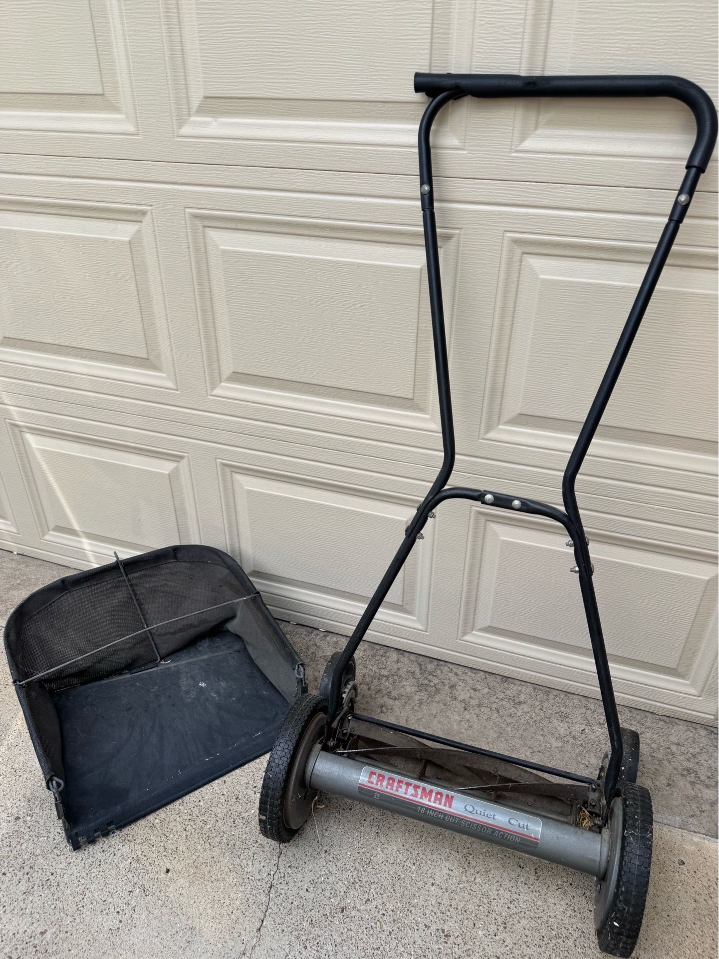 Craftsman 18-inch manual reel mower with a detachable grass catcher.
