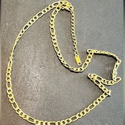 Gold tone Figaro chain necklace. Polished finish with classic link design. Lightweight and versatile for everyday wear. Approximately 17 1/2 inches.