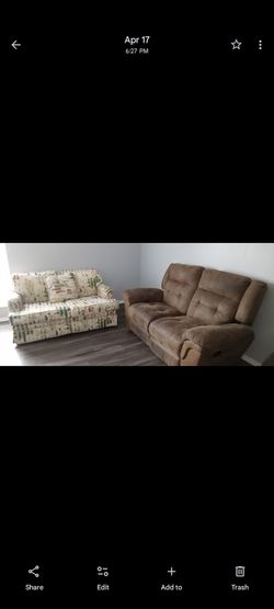 2 sofas one floral design and the other is brown leather....