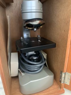 This is a vintage American Optical (AO) monocular microscope in a wooden case.