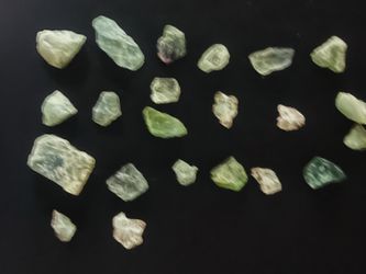 Natural raw gemstone lot contains 23pieces of uncut green stones. The material is translucent with varying shades of light to medium green and some pu