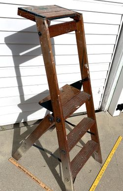 Old vintage wooden step ladder with paint splatters, display