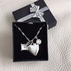 New in box silver tone charm necklace with heart and 2 faceted clear stones