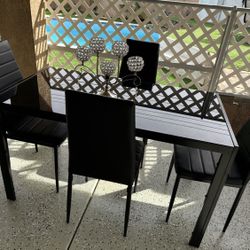 Glass dining table with four chairs. Like new.