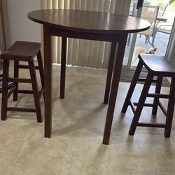 Small round high table with sides that fold down to make it more compact
