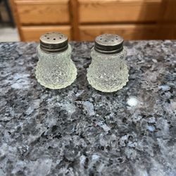 Vintage Glass pair of salt and pepper shakers. Size approximately 1 1/2 inches tall. Preowned .