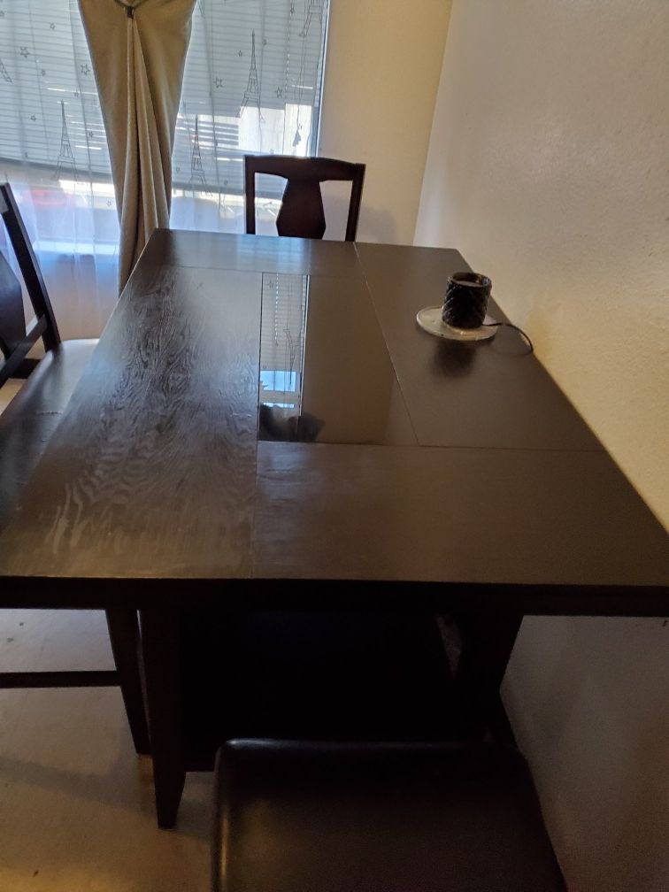 Kitchen table with two chairs and a bench.