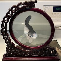 Chinese embroidered silk cat behind glass