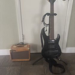 Electric Mitchell Guitar with a Speaker and a Stand