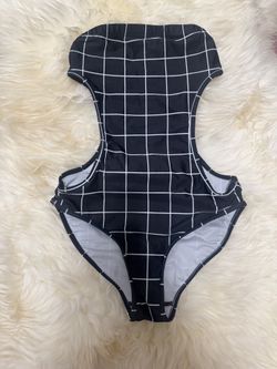Sleek one-piece with a bold grid print. Cutout sides add modern flair. Stretch fabric for easy movement. Simple, stylish swimsuit for pool or beach.