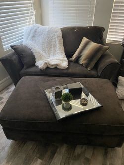 Love seat and ottoman with pillows and decor