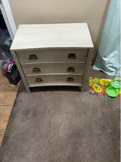 Sturdy wood chest with a light oak finish and a curved bow front
