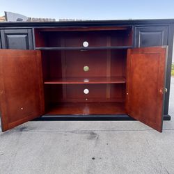 Modern black TV stand / media console with gold hardware.