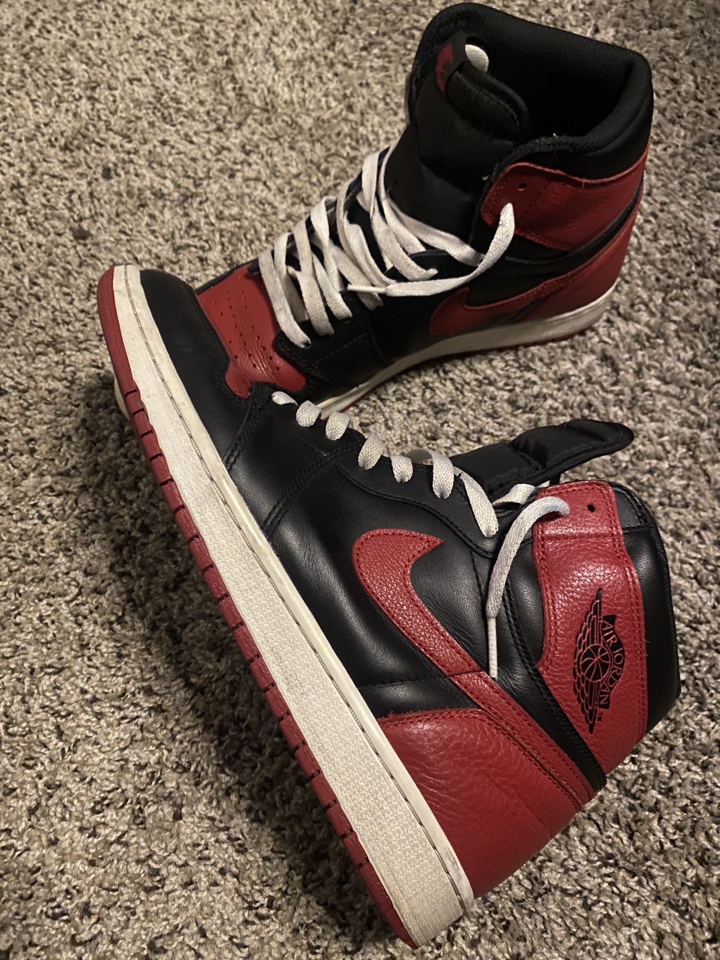 of Nike Air Jordan 1 Retro High OG NRG "Homage to Home" sneakers in a black, red, and white leather colorway