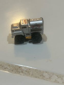 silver Hot Wheels Slime Oil / Tanker Truck (also known as a Slime Flick Car), which is a small plastic pull-back or spring-action toy released by Matt