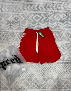 Red Godspeed shorts with white text on the side