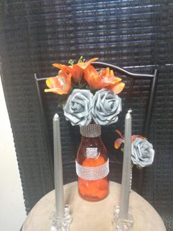 $40 Orange/ Silver- Gray roses in Orange vase with Silver rhinestones on vase, boutonniere, (2) tall gray candles + (2) crystal candle holders.
