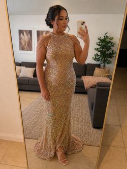shimmering rose gold sequined halter evening gown with a floor-length mermaid silhouette.
