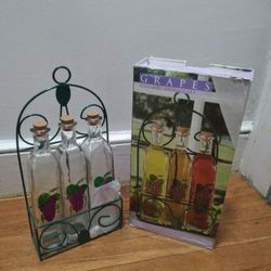 4 Piece Clear Glass Bottle Storage Set Featuring A Grape Design, Cork Lids, And A Green Metal Rack With Box