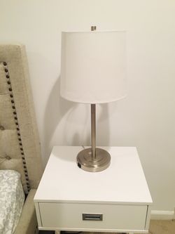 2 beautiful chrome bedside lights with white shade and phone charger outlet .