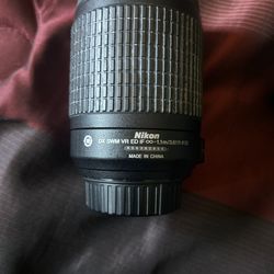 Nikon AF-S DX Zoom-NIKKOR 55-200mm f/4-5.6G ED lens and Nikon MH-24 battery charger, and a packaged Nikon EN-EL14 battery