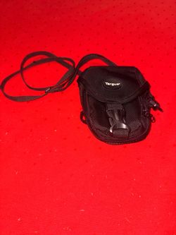 black Targus compact digital camera case/pouch with a front buckle closure and an attached shoulder strap