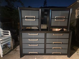 Black dresser featuring gray upholstered drawers.