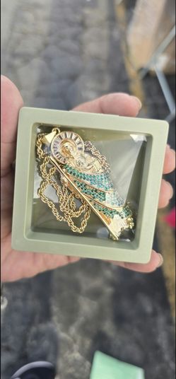This is a gold-toned Our Lady of Guadalupe necklace