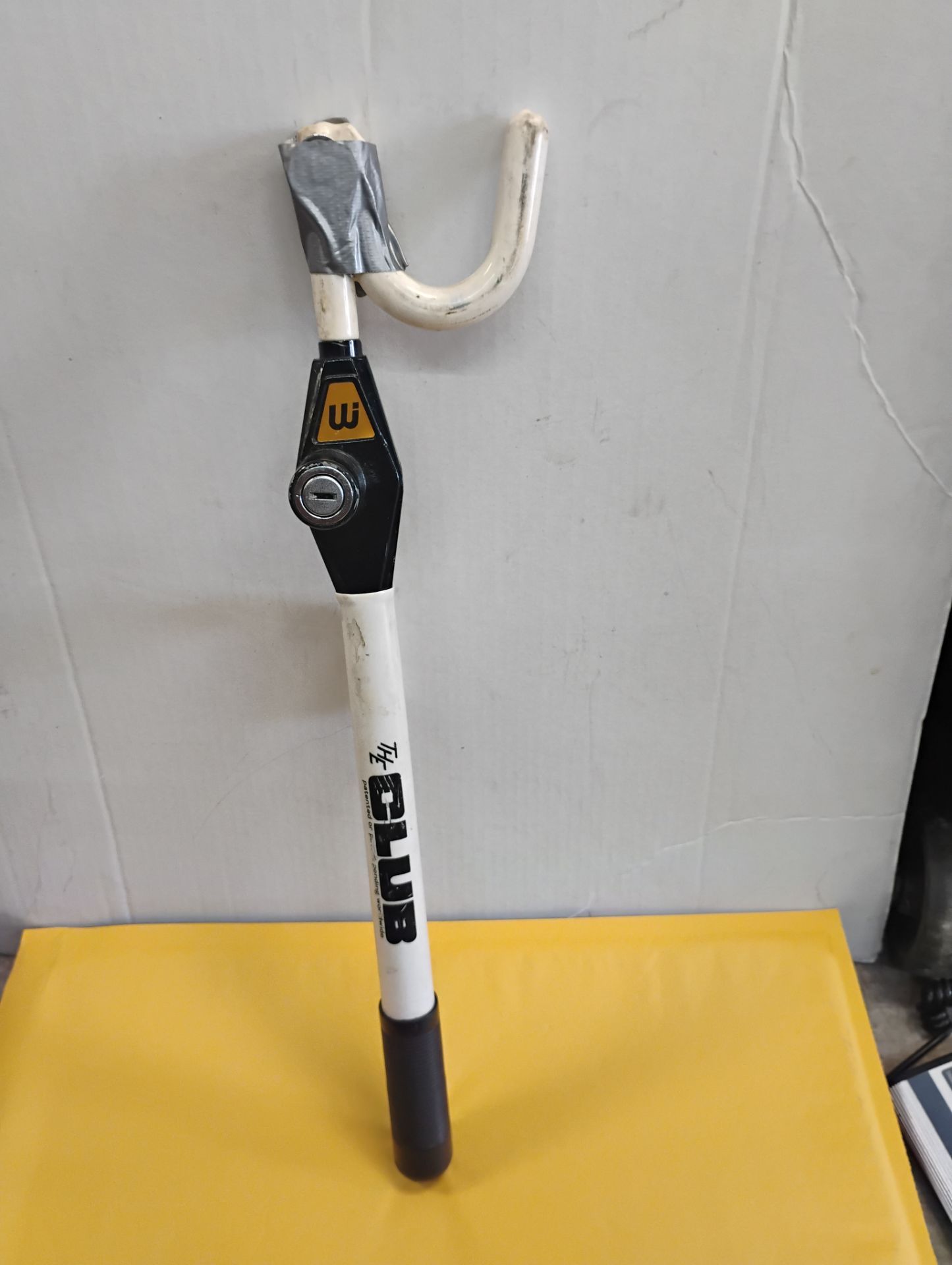 The Club" steering wheel lock with key designed to prevent vehicle theft by locking the steering wheel in place