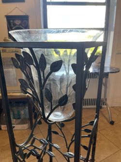 An Iron Wrought Wine Bottle Stand With A Bowl For Ice