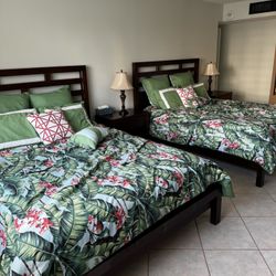 2 wooden queen beds with side tables and vanity 