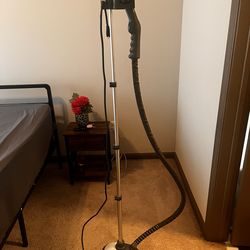 Queen bed and two side tables and standing steamer