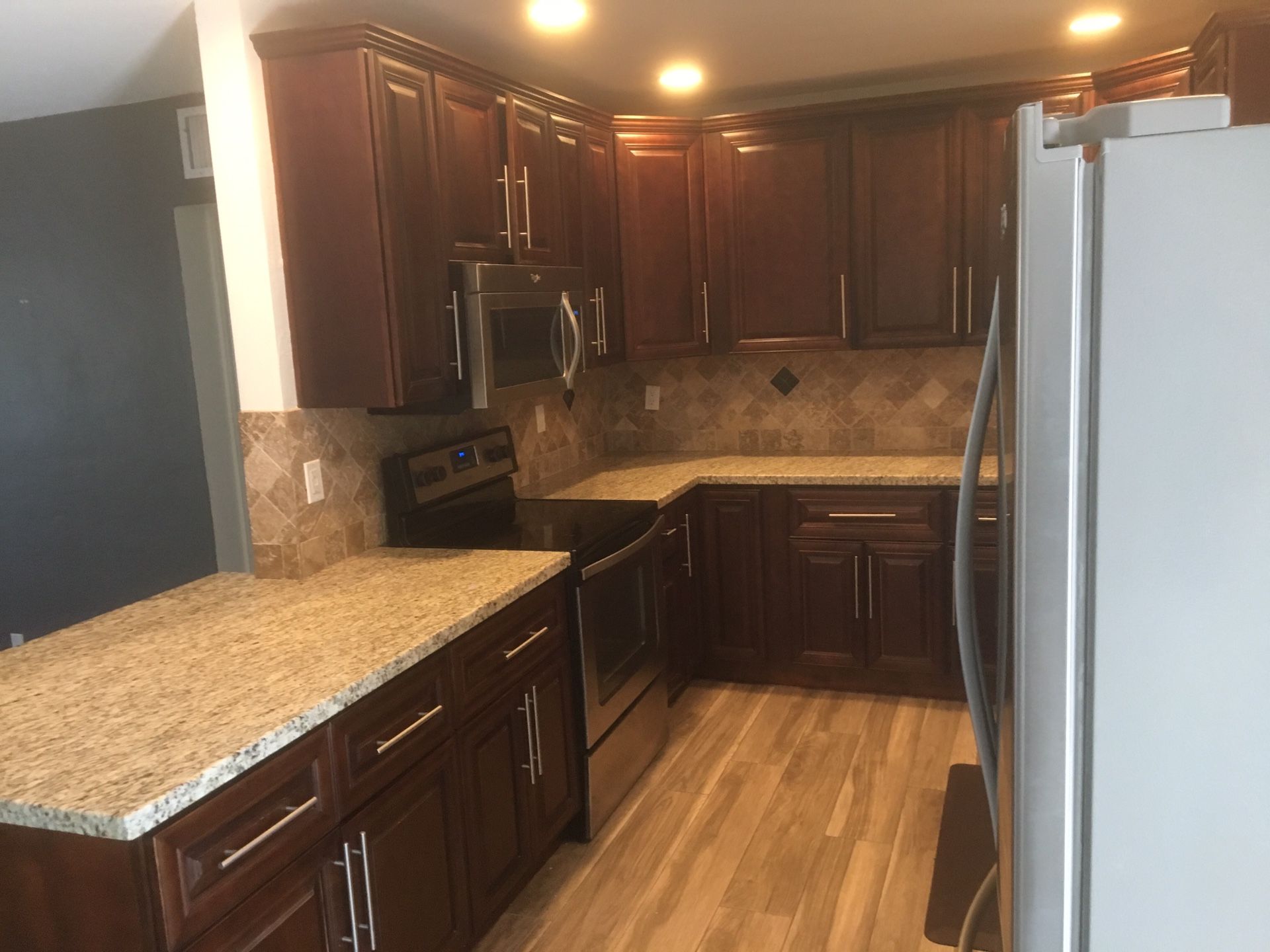 Kitchen cabinets, granite Countertops, dishwasher, and sink with disposal