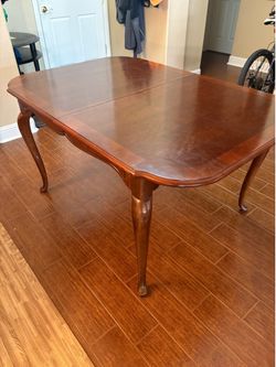 Dining table with protective cover and extra leaf