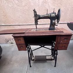 Vintage White sewing machine housed in a wooden cabinet with twig-style detailing on the front logo.