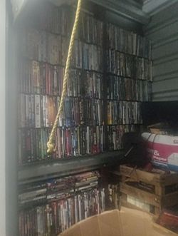 Storage unit filled with dvds, vhs, cds, cassette tapes, & video games