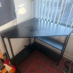 Black wooden corner desk with outlets