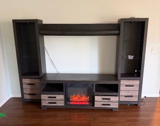 By Ashley Modern entertainment center with a built-in electric fireplace insert