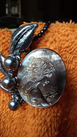 Cameo pendant with 3 large gray pearls.