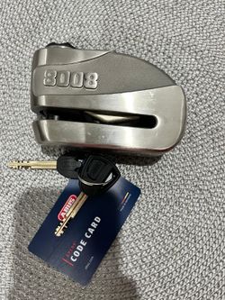 ABUS GRANIT Detecto XPlus 8008 is a high-security motorcycle and scooter brake disc lock featuring an integrated electronic alarm system.