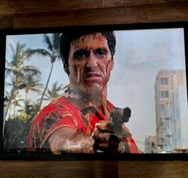 framed artwork displays an iconic scene from the 1983 crime drama classic Scarface, starring Al Pacino as the notorious gangster Tony Montana.This spe