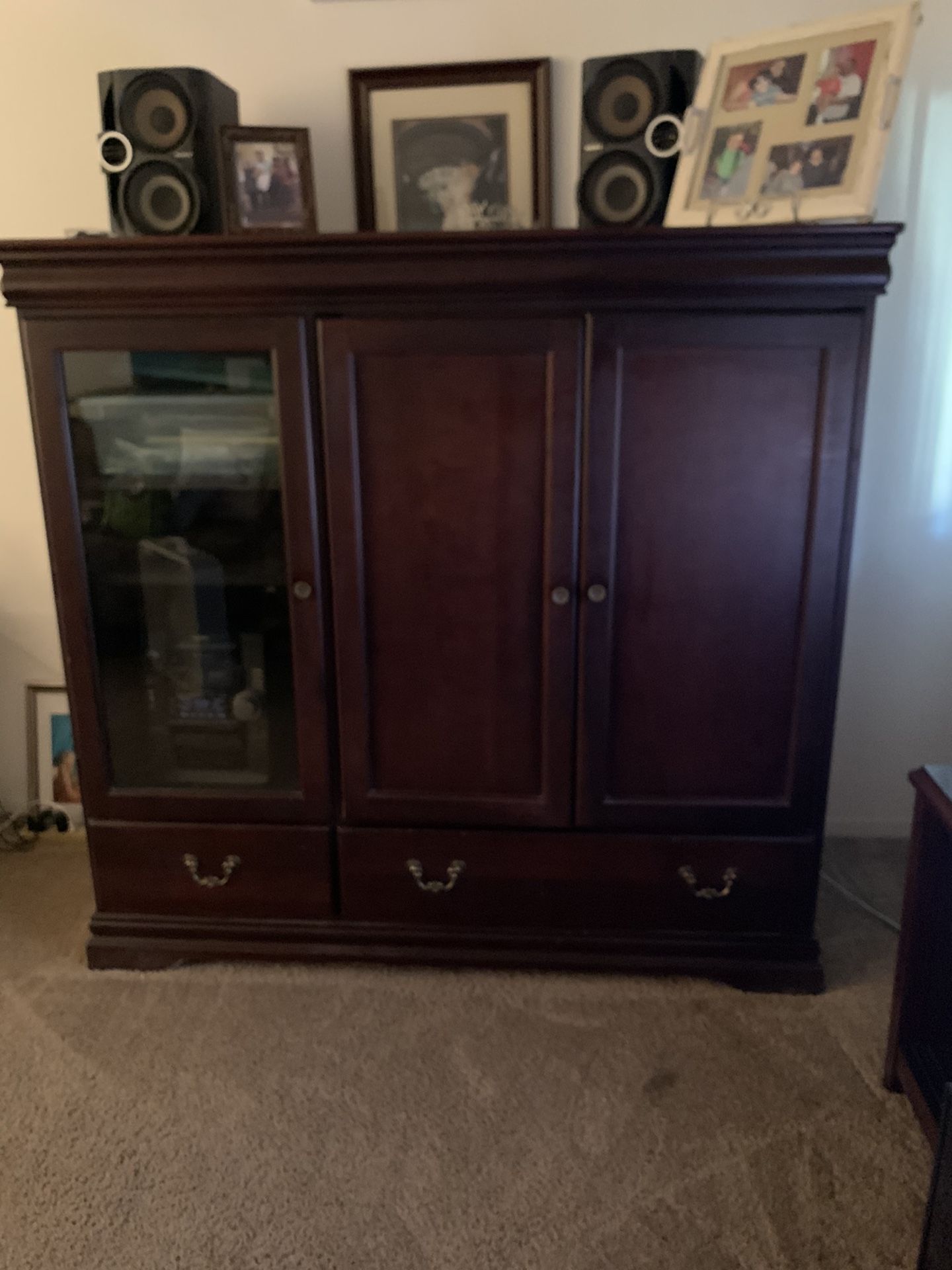 Cherry Wood entertainment center 2 drawers on the bottom left side glass door enough space for disc player on the right side the 2 brown door open an