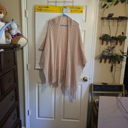 A beige, open-front knit fringe poncho shawl with a textured wave pattern.