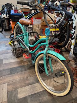 Schwinn cruiser bike with floral patterned seat and white wall tires.